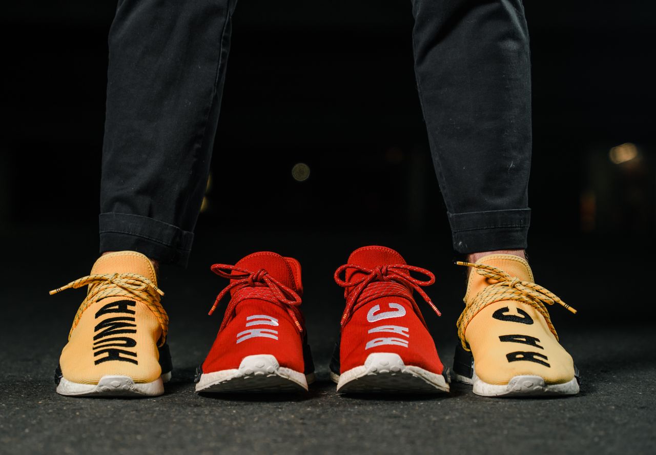 about-us Vibrant red and yellow sneakers with bold text capture attention in a city night setting.