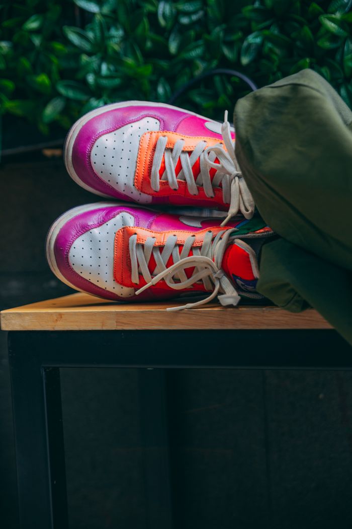 Vibrant sneakers showcasing colorful design with laces resting on a table.